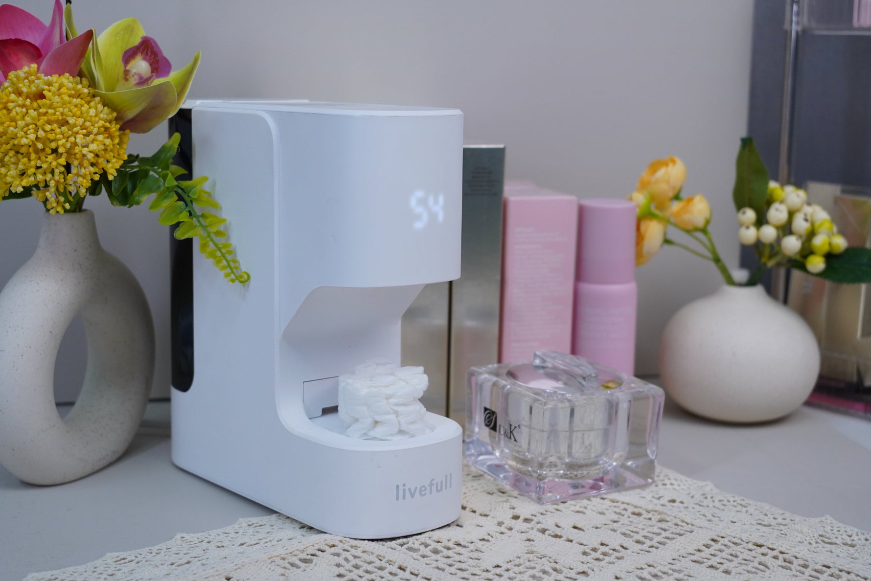 sleek towel warmer on marble counter with steaming rolled towels in soft warm light
